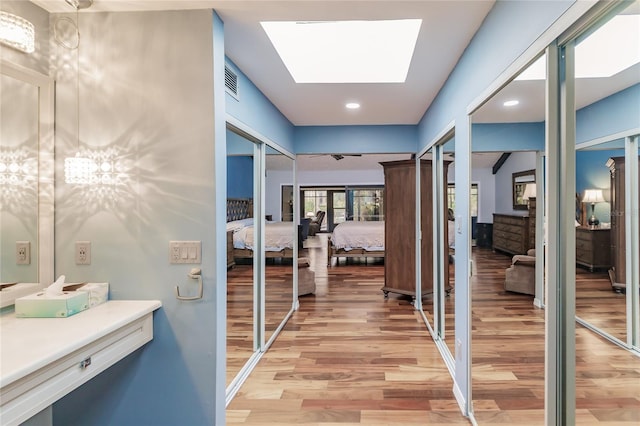 bathroom with a skylight and hardwood / wood-style floors