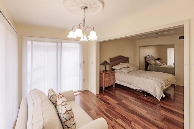 bedroom with dark hardwood / wood-style floors and an inviting chandelier