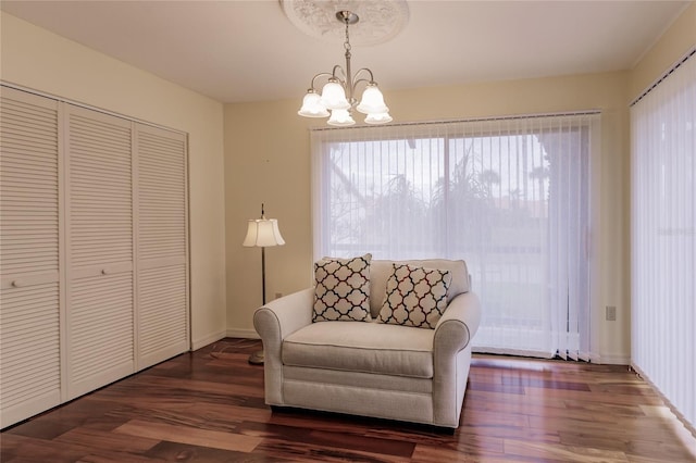 living area featuring dark hardwood / wood-style floors and an inviting chandelier