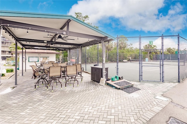 view of patio featuring tennis court and ceiling fan