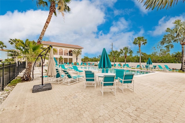 view of swimming pool featuring a water view and a patio