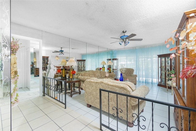 living room featuring ceiling fan, light tile patterned floors, and a textured ceiling