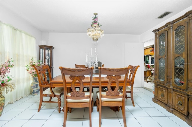 dining space featuring light tile patterned floors and a notable chandelier