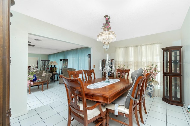 tiled dining room with a chandelier