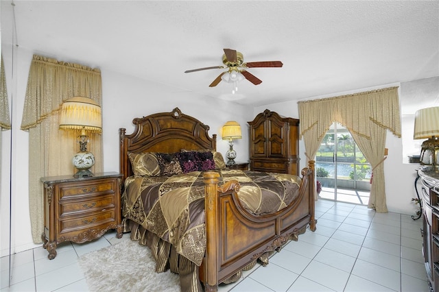 bedroom with access to outside, ceiling fan, light tile patterned floors, and a textured ceiling