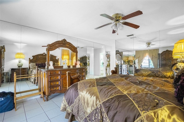 bedroom featuring ceiling fan, light tile patterned flooring, and a textured ceiling