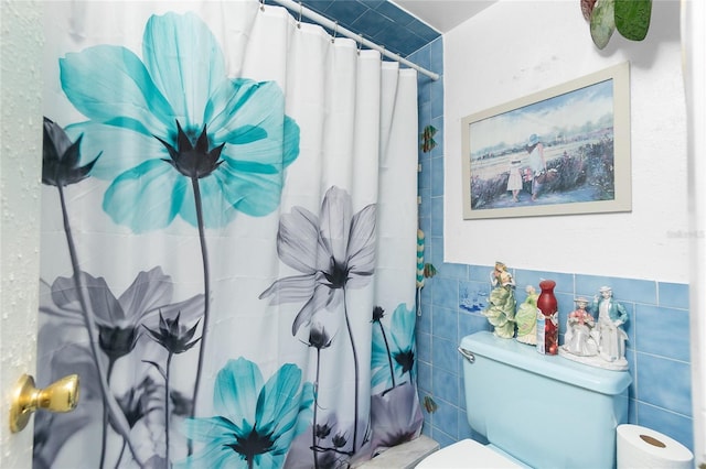 bathroom featuring toilet, tile walls, and walk in shower