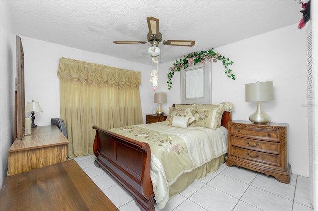 bedroom with light tile patterned floors, a textured ceiling, and ceiling fan