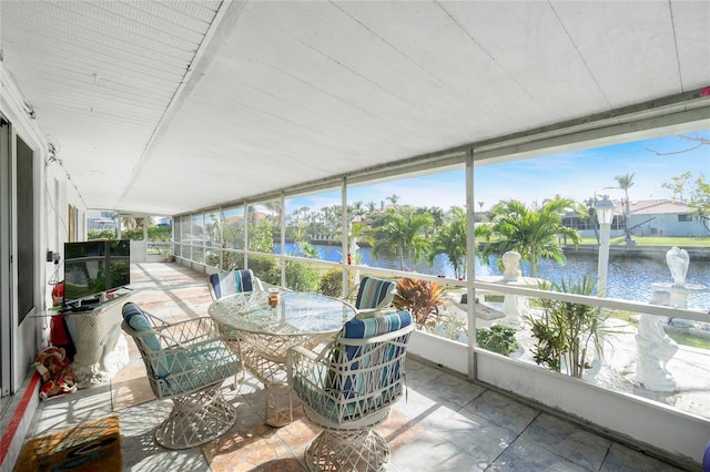 sunroom featuring a water view