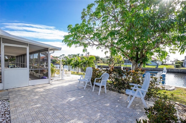 view of patio / terrace with a sunroom and a water view