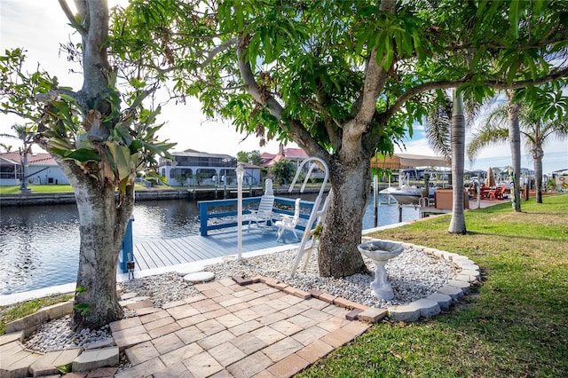 view of dock featuring a lawn and a water view