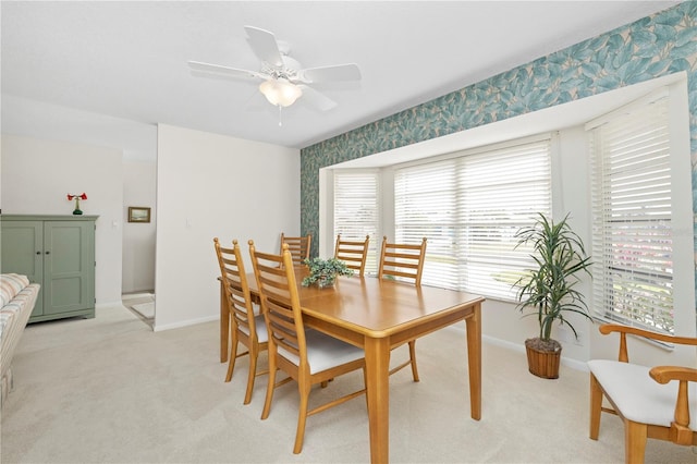 carpeted dining space with ceiling fan