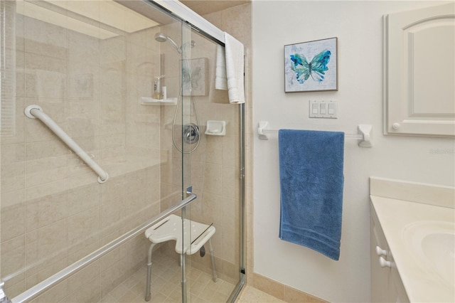 bathroom featuring a shower with shower door and vanity