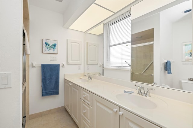 bathroom with a shower with door, tile patterned floors, toilet, and vanity