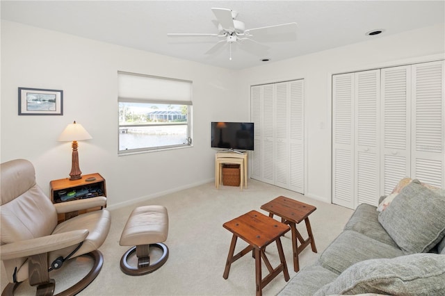 living room with ceiling fan and light colored carpet