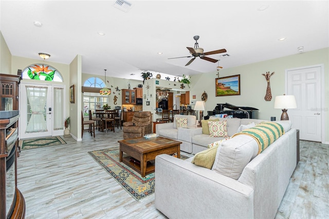 living room with ceiling fan and light hardwood / wood-style flooring