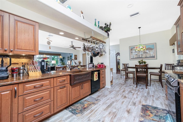 kitchen with stove, dark stone countertops, black dishwasher, tasteful backsplash, and decorative light fixtures