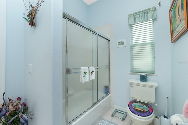 bathroom with tile patterned flooring, enclosed tub / shower combo, and toilet