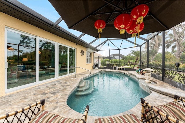 view of swimming pool with glass enclosure and a patio area