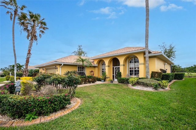 mediterranean / spanish home with a garage and a front yard