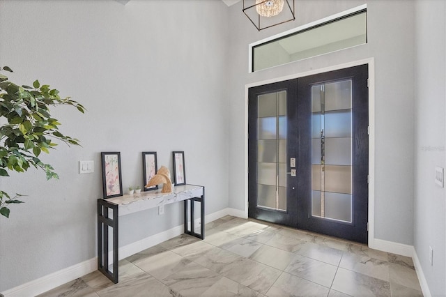 foyer with french doors and a chandelier