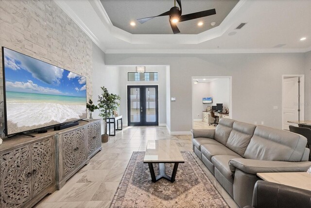 living room with french doors, a tray ceiling, ceiling fan, and crown molding