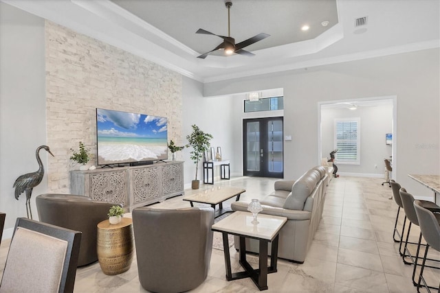 living room with french doors, a tray ceiling, ceiling fan, and crown molding