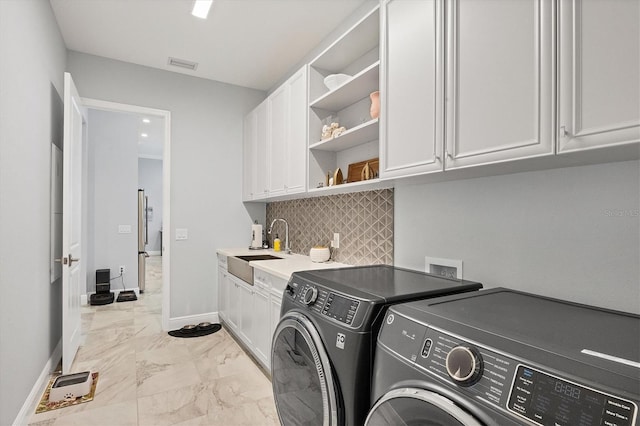 laundry room with washer and dryer, cabinets, and sink