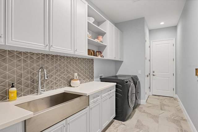 laundry room with cabinets, independent washer and dryer, and sink