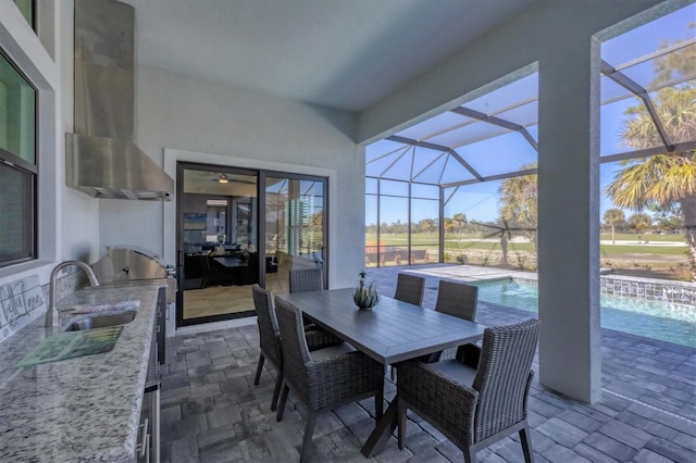 view of patio featuring an outdoor kitchen, sink, and glass enclosure