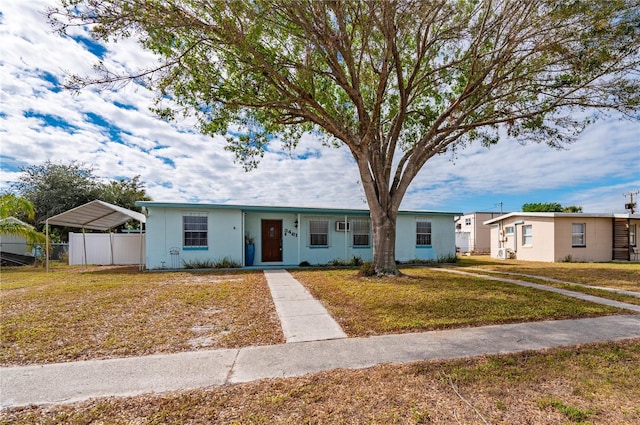 ranch-style home with a front yard and a carport