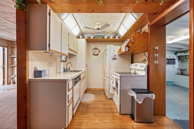 kitchen with white cabinetry, vaulted ceiling with skylight, white electric range oven, sink, and ceiling fan