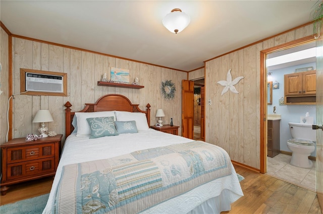 bedroom with light wood-type flooring, ensuite bathroom, a wall mounted AC, and crown molding