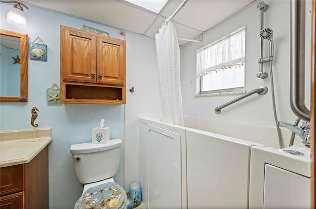 full bathroom featuring vanity, toilet, shower / bath combo with shower curtain, and a drop ceiling