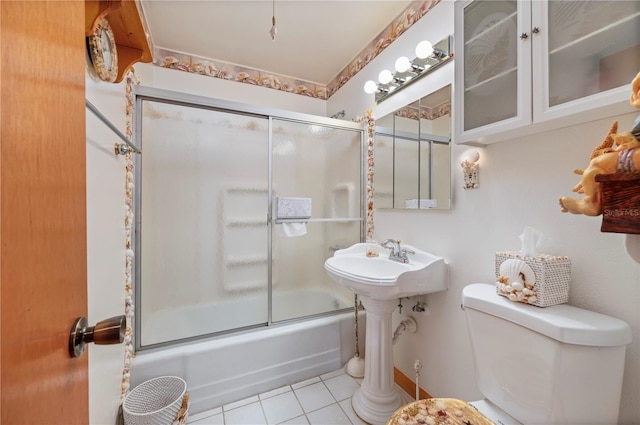 bathroom featuring bath / shower combo with glass door, toilet, and tile patterned flooring