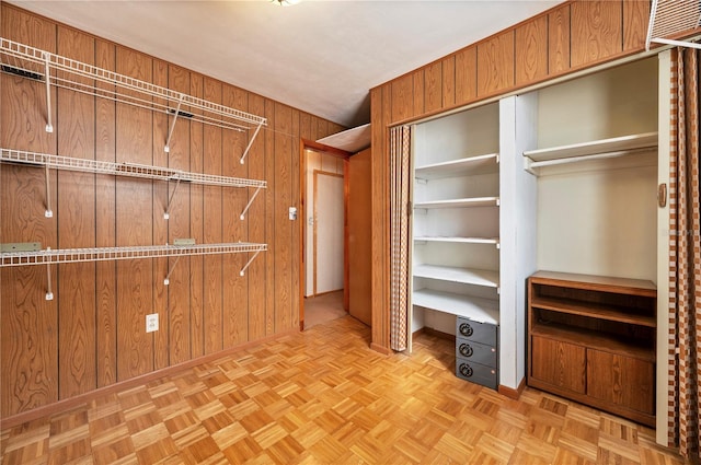 walk in closet with light parquet flooring