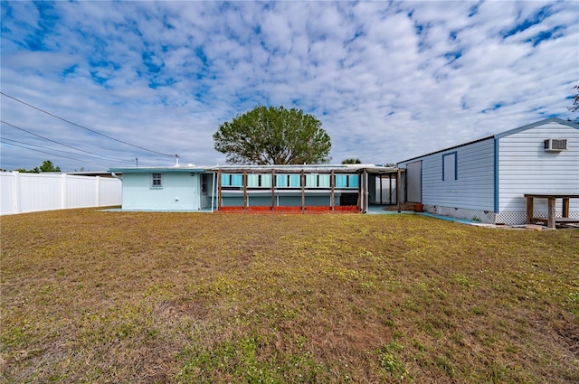 back of house with an AC wall unit and a yard