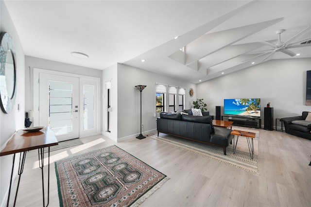 living room with light hardwood / wood-style floors, vaulted ceiling, and ceiling fan