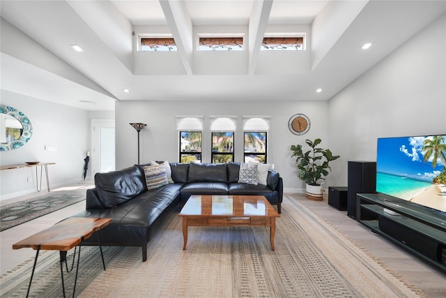 living room with a towering ceiling and light hardwood / wood-style flooring