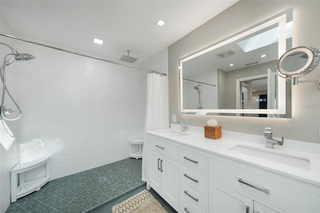 bathroom with tile patterned flooring, vanity, a skylight, and walk in shower