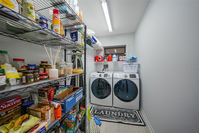 clothes washing area featuring washer and clothes dryer and hardwood / wood-style flooring