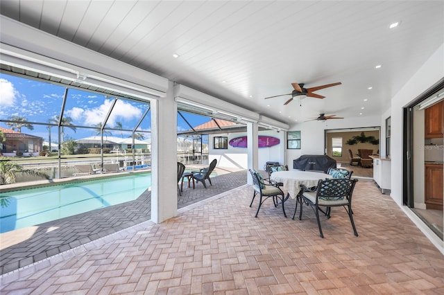 view of patio / terrace featuring glass enclosure, ceiling fan, and a grill