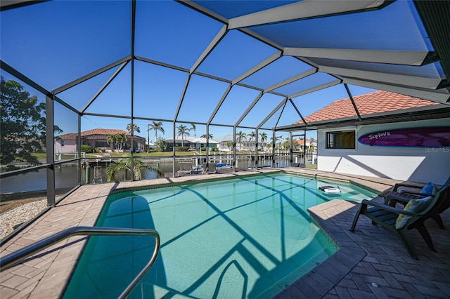 view of swimming pool featuring glass enclosure and a water view