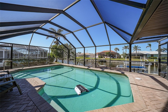 view of swimming pool with a lanai, a water view, a patio, and a dock