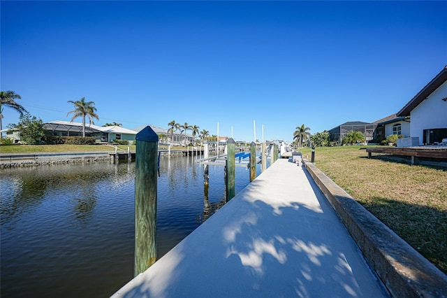 dock area with a water view and a lawn