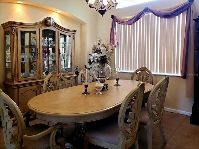 tiled dining room featuring an inviting chandelier and a wealth of natural light