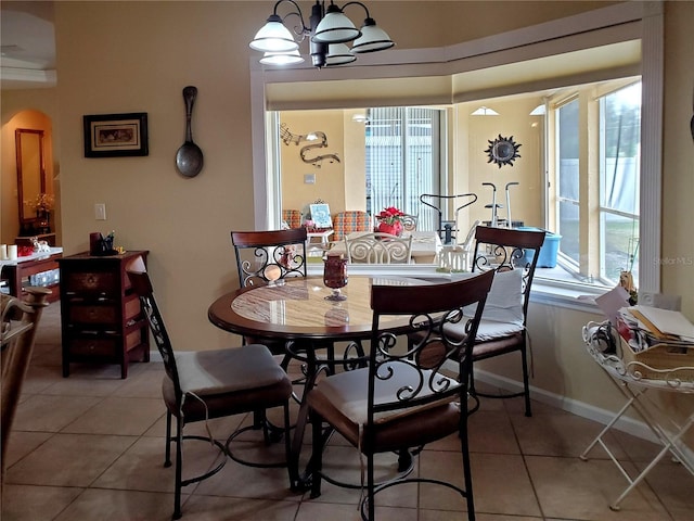 tiled dining room featuring an inviting chandelier