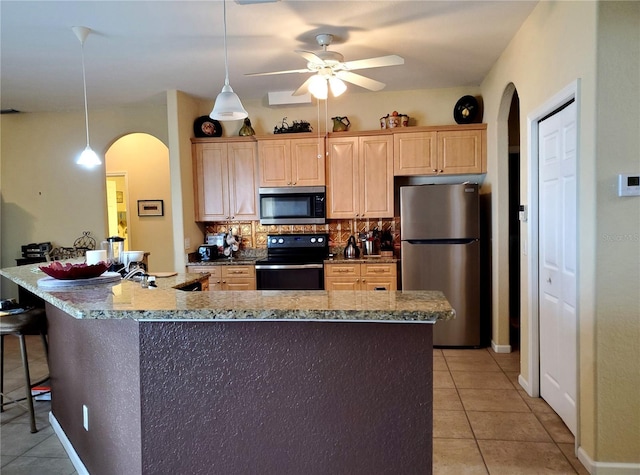 kitchen featuring a kitchen island with sink, backsplash, stainless steel appliances, ceiling fan, and light tile patterned flooring