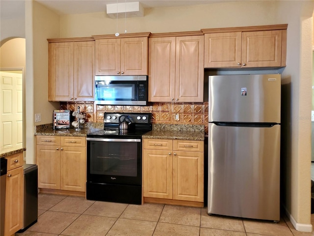 1057 Staley St, Port Charlotte, FL 33952 - kitchen featuring light brown cabinets, stainless steel appliances, dark stone countertops, and tasteful backsplash