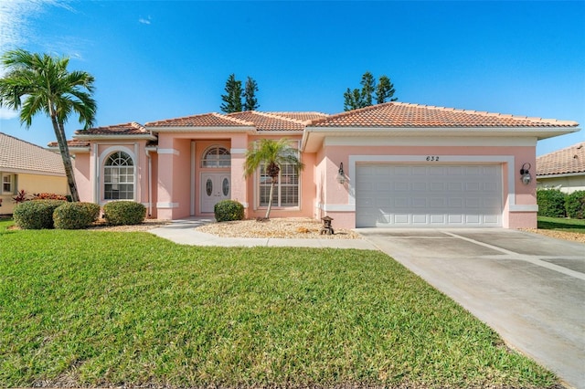 mediterranean / spanish home featuring a garage and a front yard